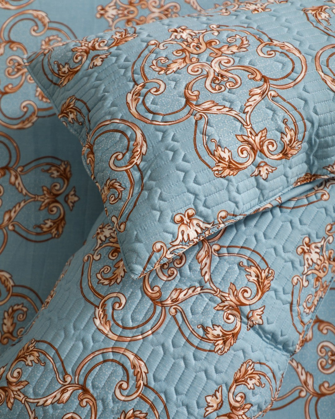Blue king size bedsheet with intricate royal motifs and matching quilted pillow cover close up