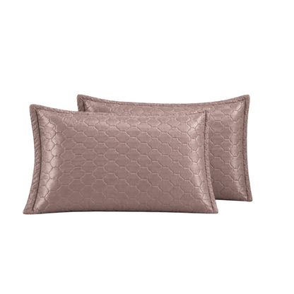 Two rectangular lumbar pillows in a dusty rose metallic finish with a raised geometric honeycomb pattern, shown against a plain white background.