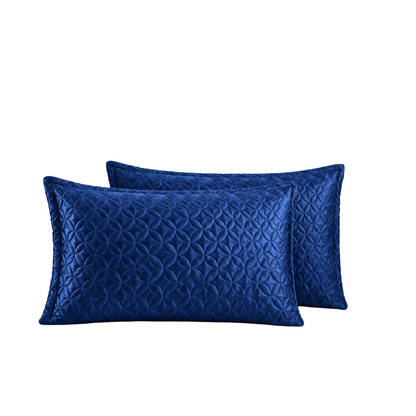 Two royal blue quilted rectangular throw pillows with a geometric pattern, displayed against a solid white background.